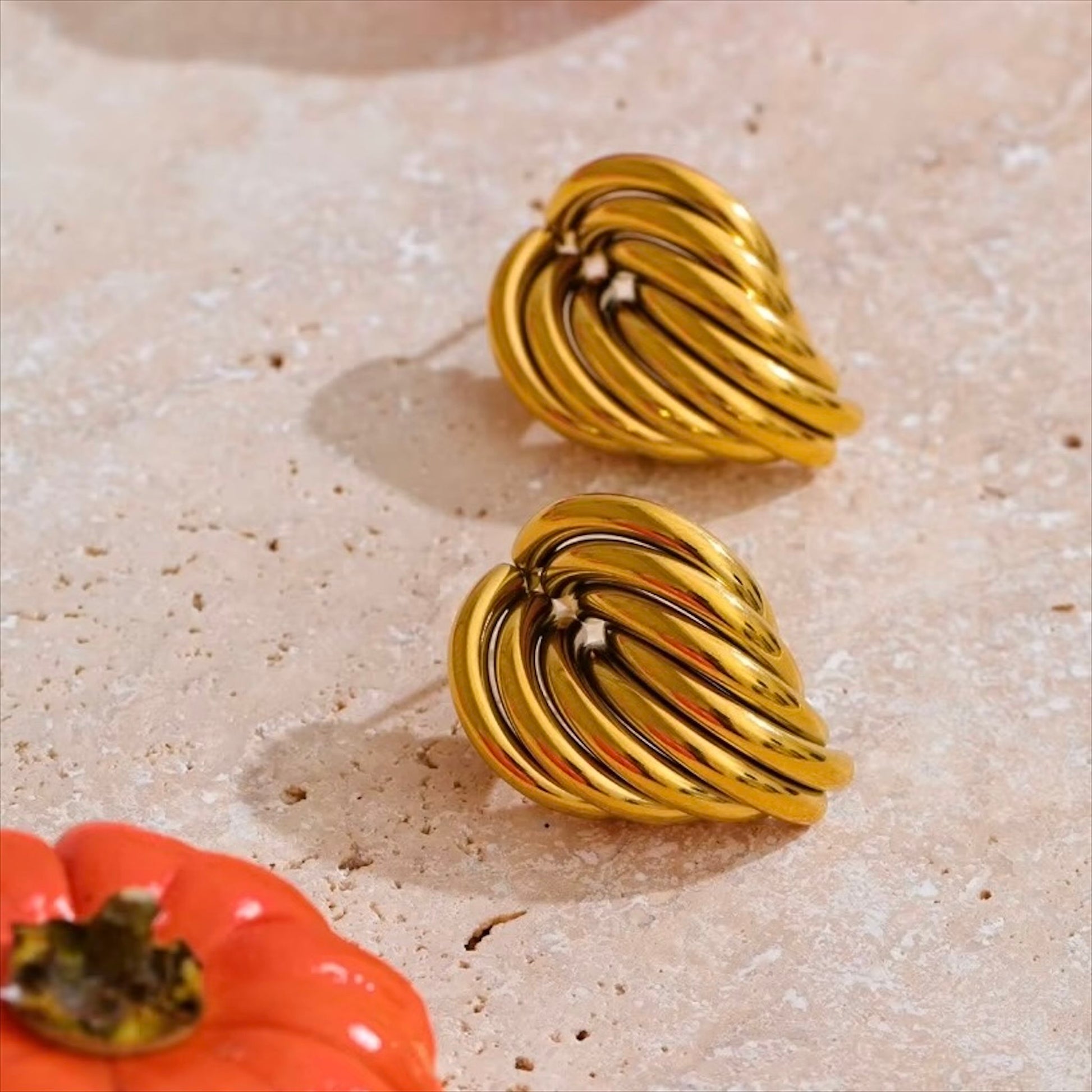 Boucles d'oreilles dorées en acier inoxydable au design ondulé pour femme, élégance et modernité.