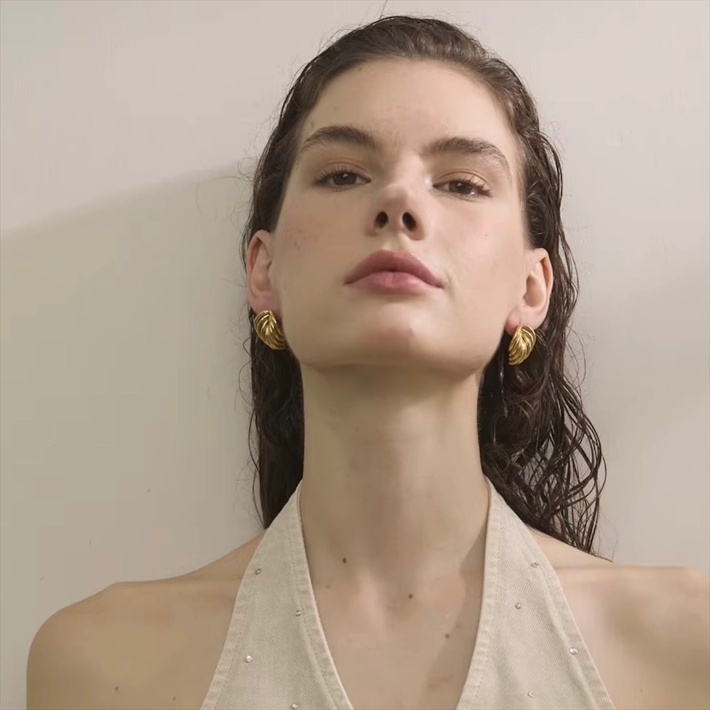 Boucles d'oreilles dorées en acier inoxydable au design ondulé pour femme, élégance et modernité.