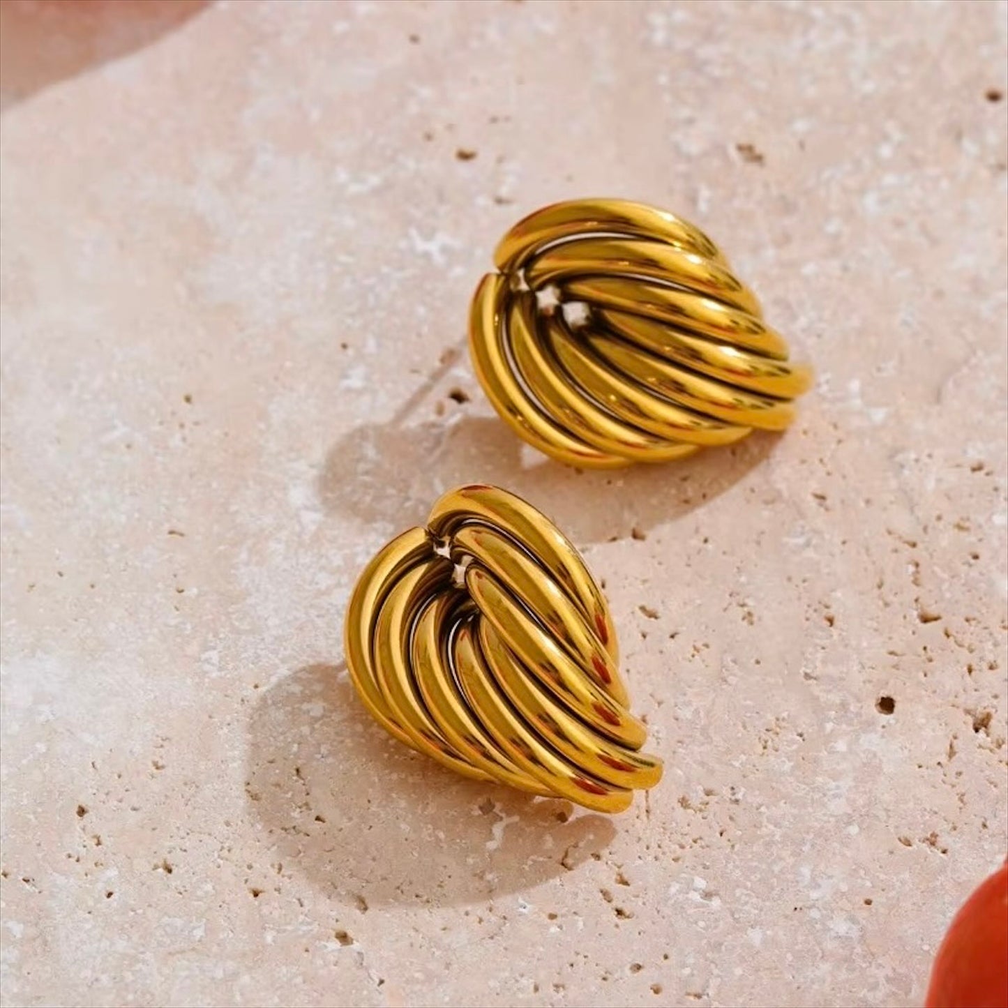 Boucles d'oreilles dorées en acier inoxydable au design ondulé pour femme, élégance et modernité.