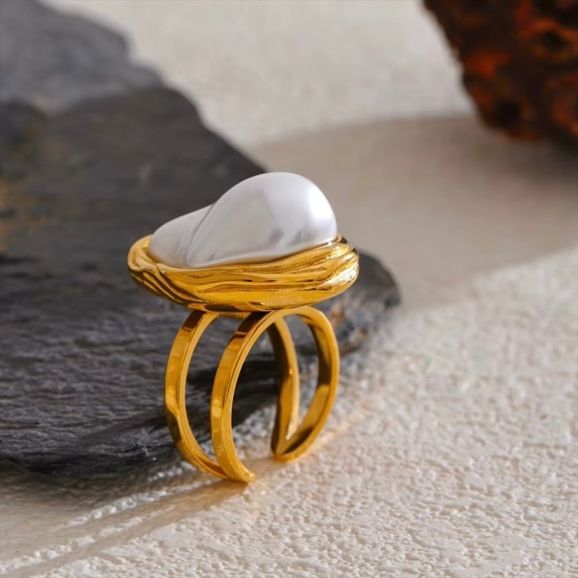 Bague dorée en acier inoxydable ornée d’une grande perle blanche imitation baroque, bijou élégant et original pour femme - Bijoux Prestige.