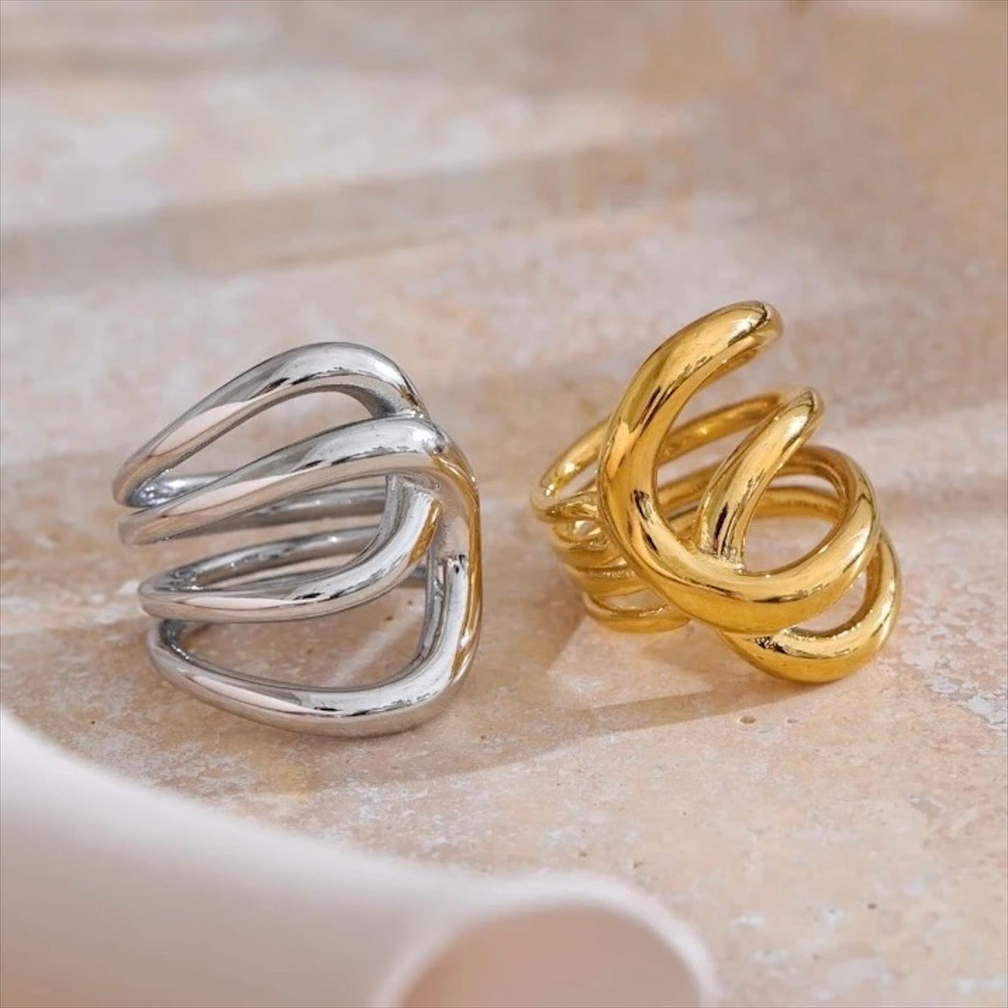 Bagues entrelacées en acier inoxydable, finitions dorée et argentée, bijou design et moderne pour femme.