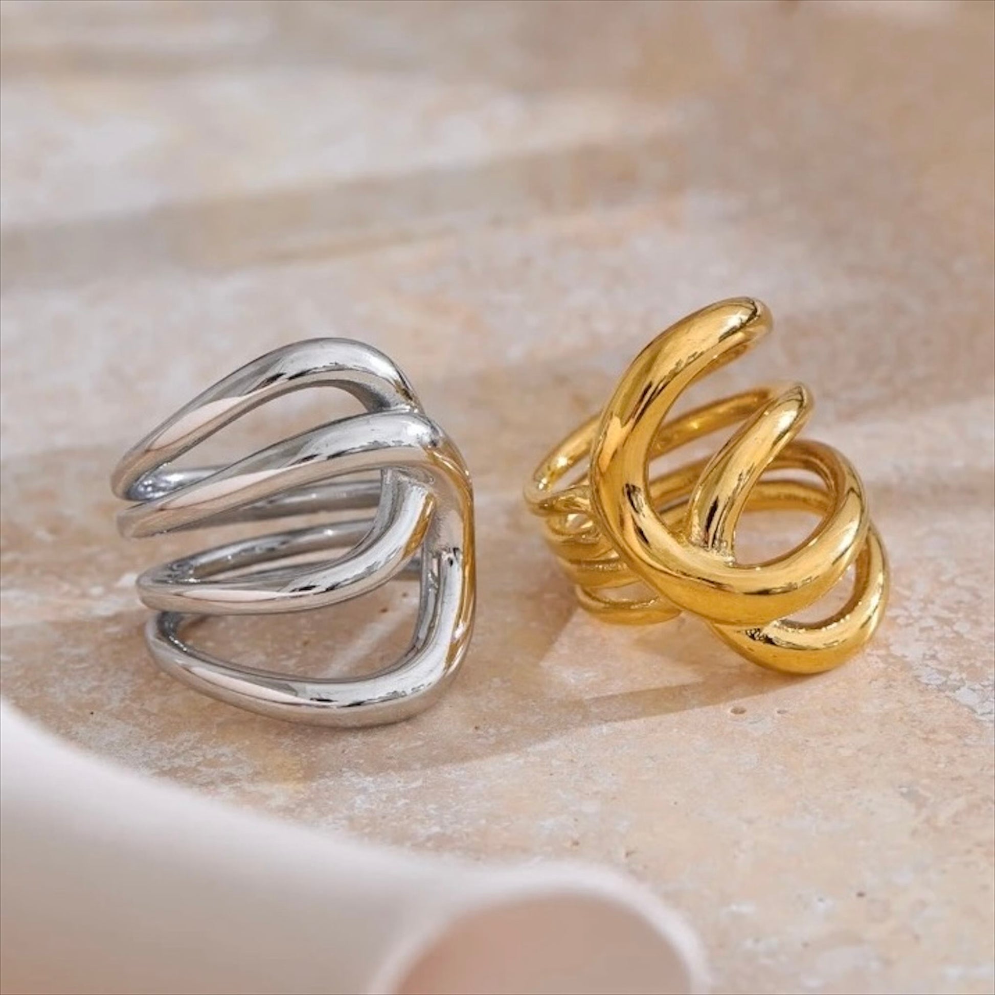 Bagues entrelacées en acier inoxydable, finitions dorée et argentée, bijou design et moderne pour femme.