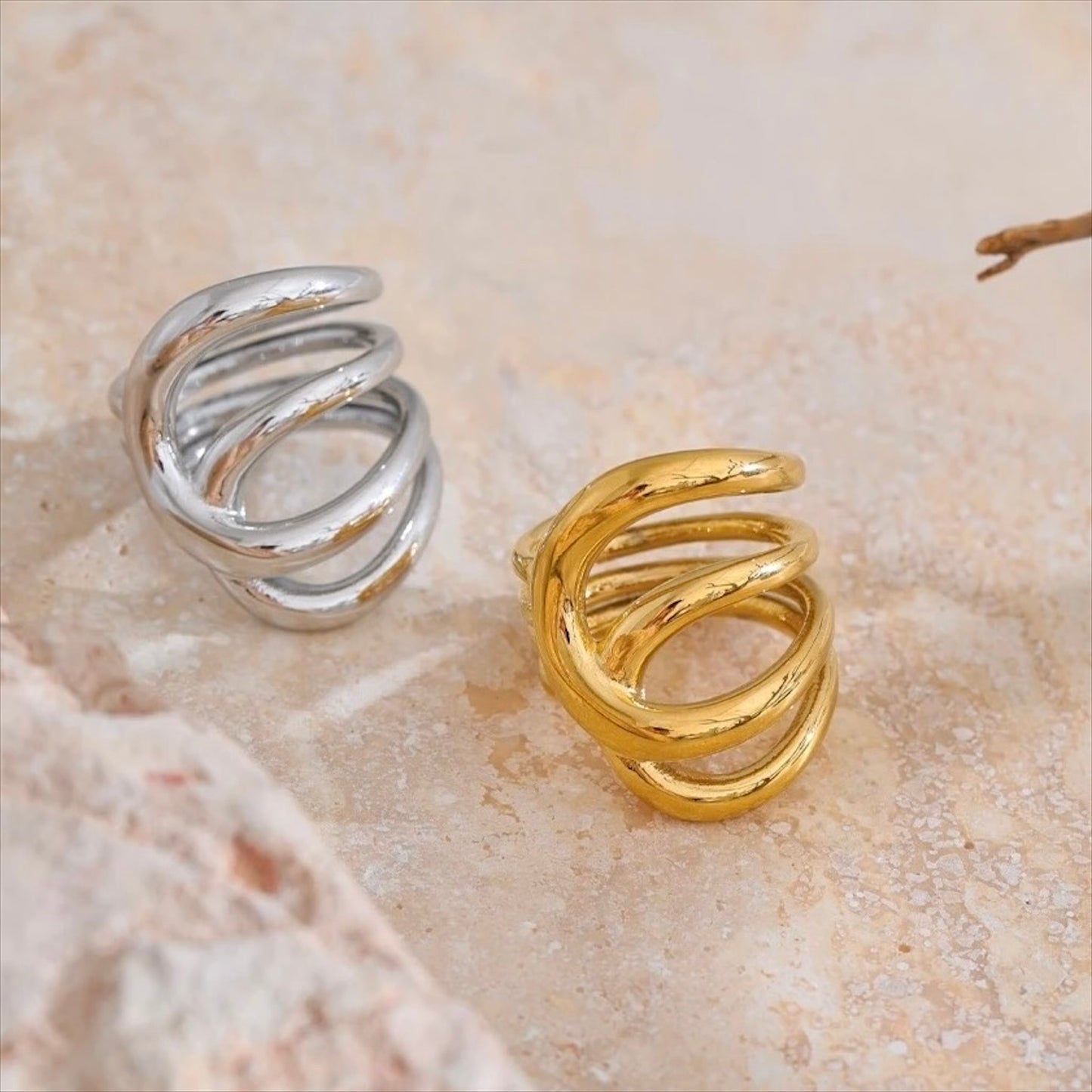 Bagues entrelacées en acier inoxydable, finitions dorée et argentée, bijou design et moderne pour femme.
