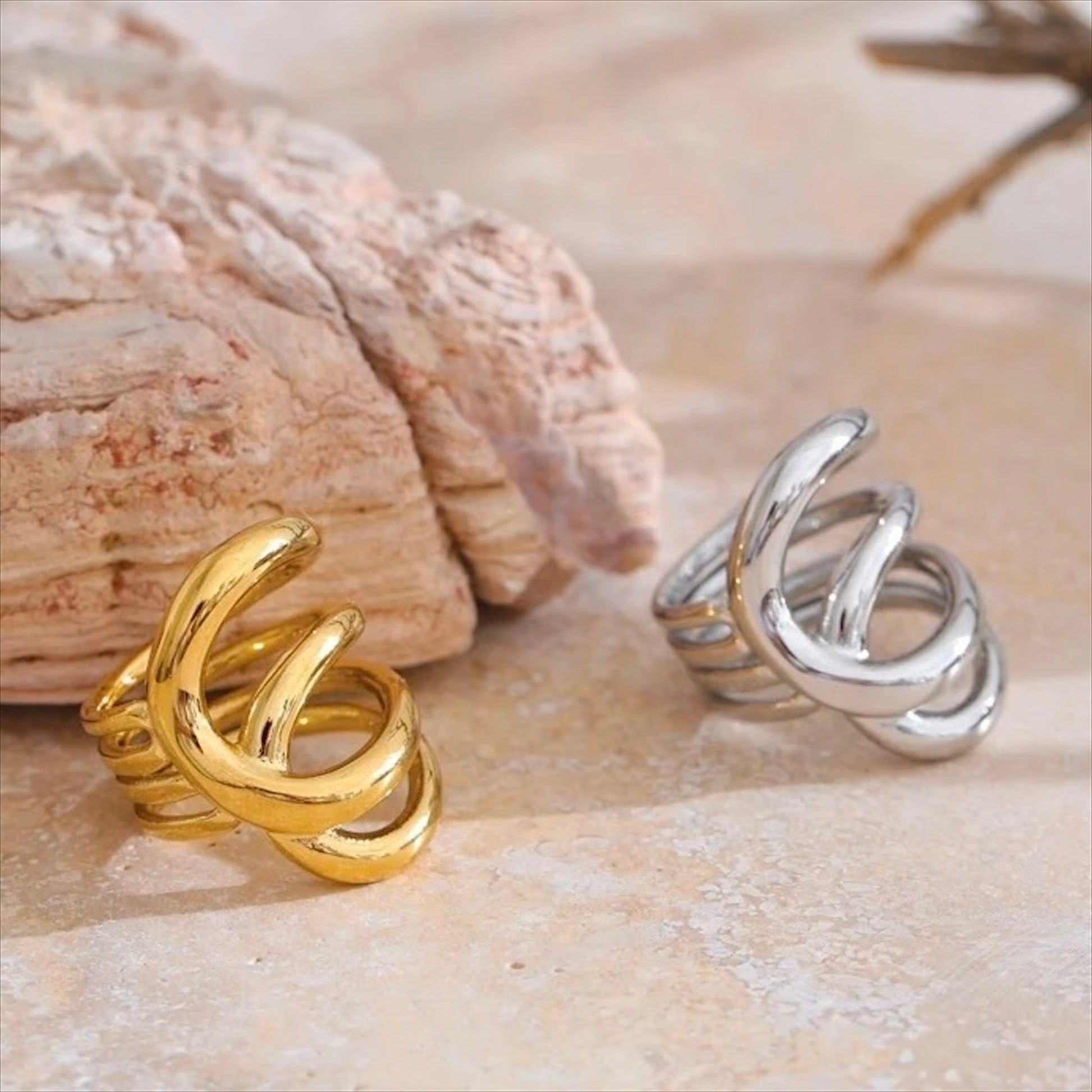 Bagues entrelacées en acier inoxydable, finitions dorée et argentée, bijou design et moderne pour femme.