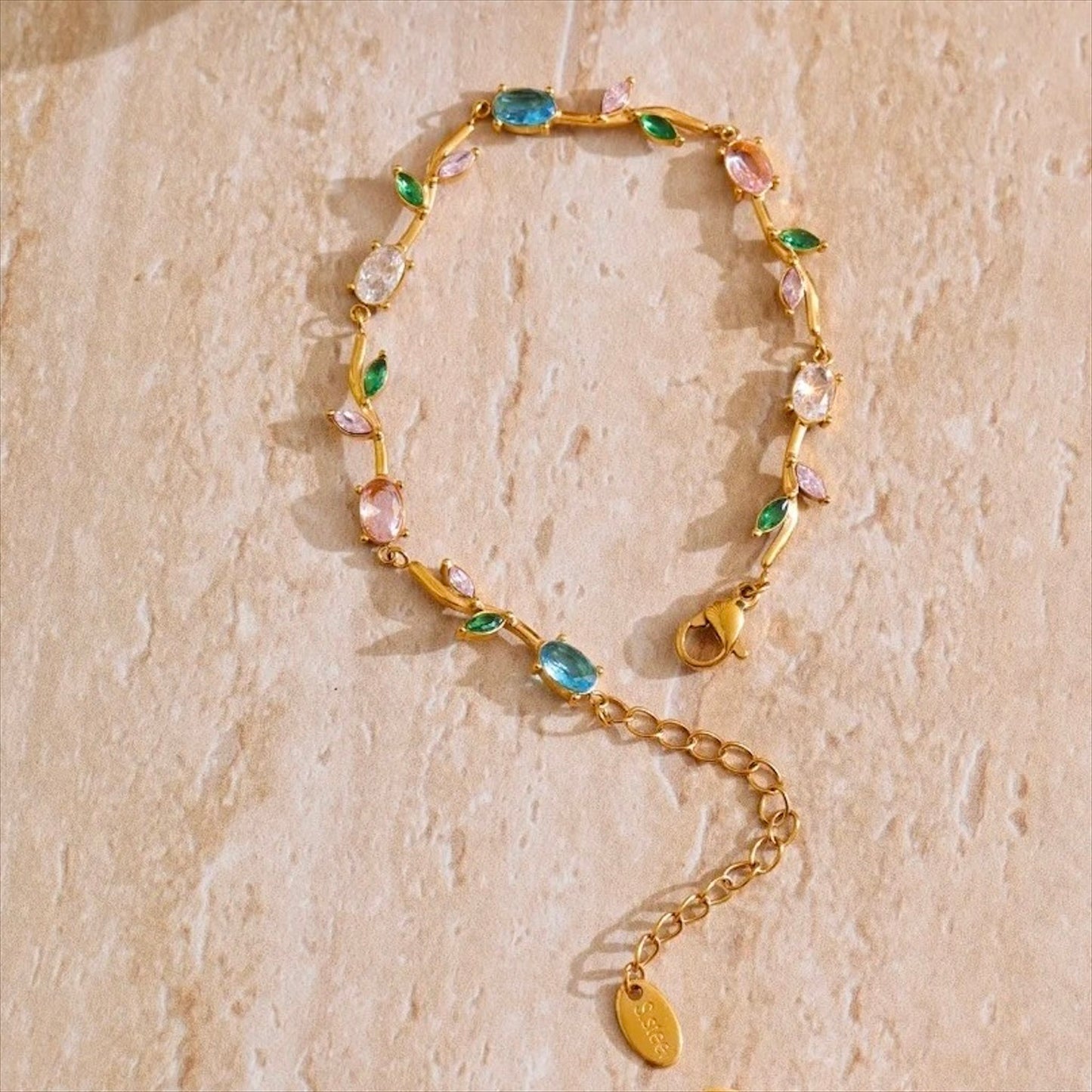 Bracelet fin doré en acier inoxydable serti de zirconiums multicolores, bijou raffiné pour femme.