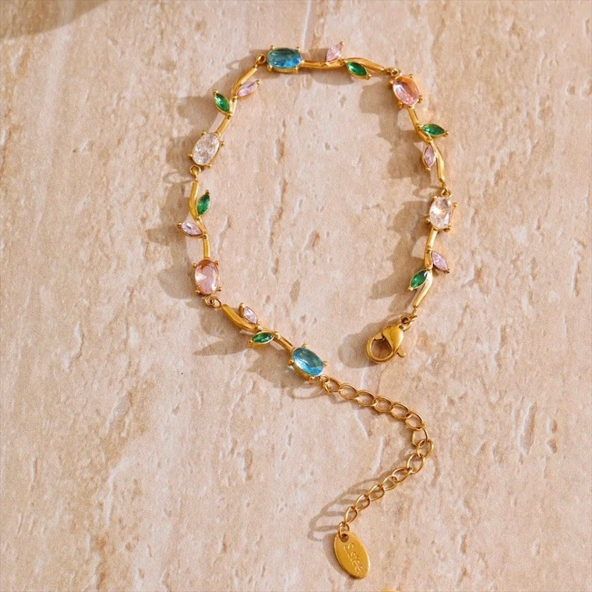 Bracelet fin doré en acier inoxydable serti de zirconiums multicolores, bijou raffiné pour femme.