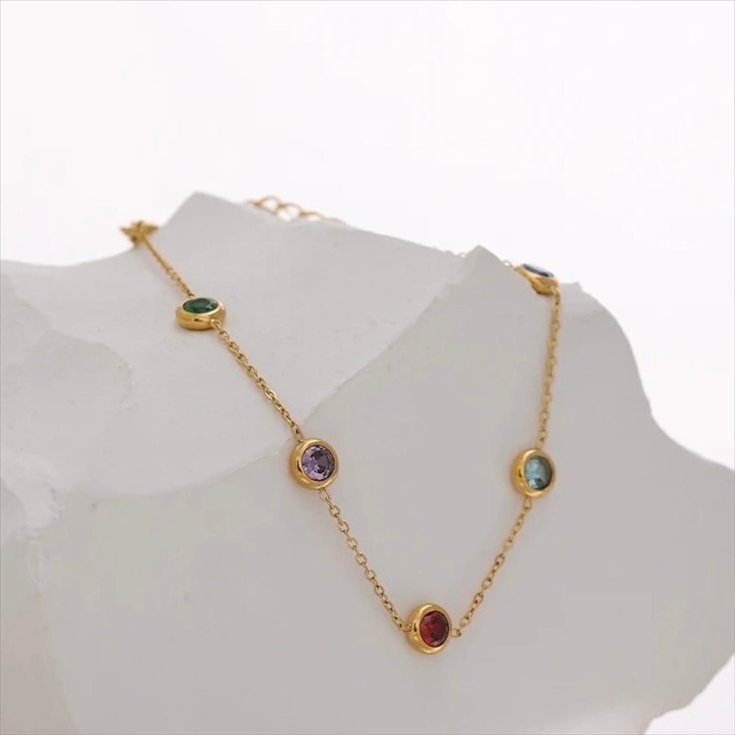 Bracelet fin doré en acier inoxydable avec pampilles pierres colorées, bijou délicat et tendance pour femme.