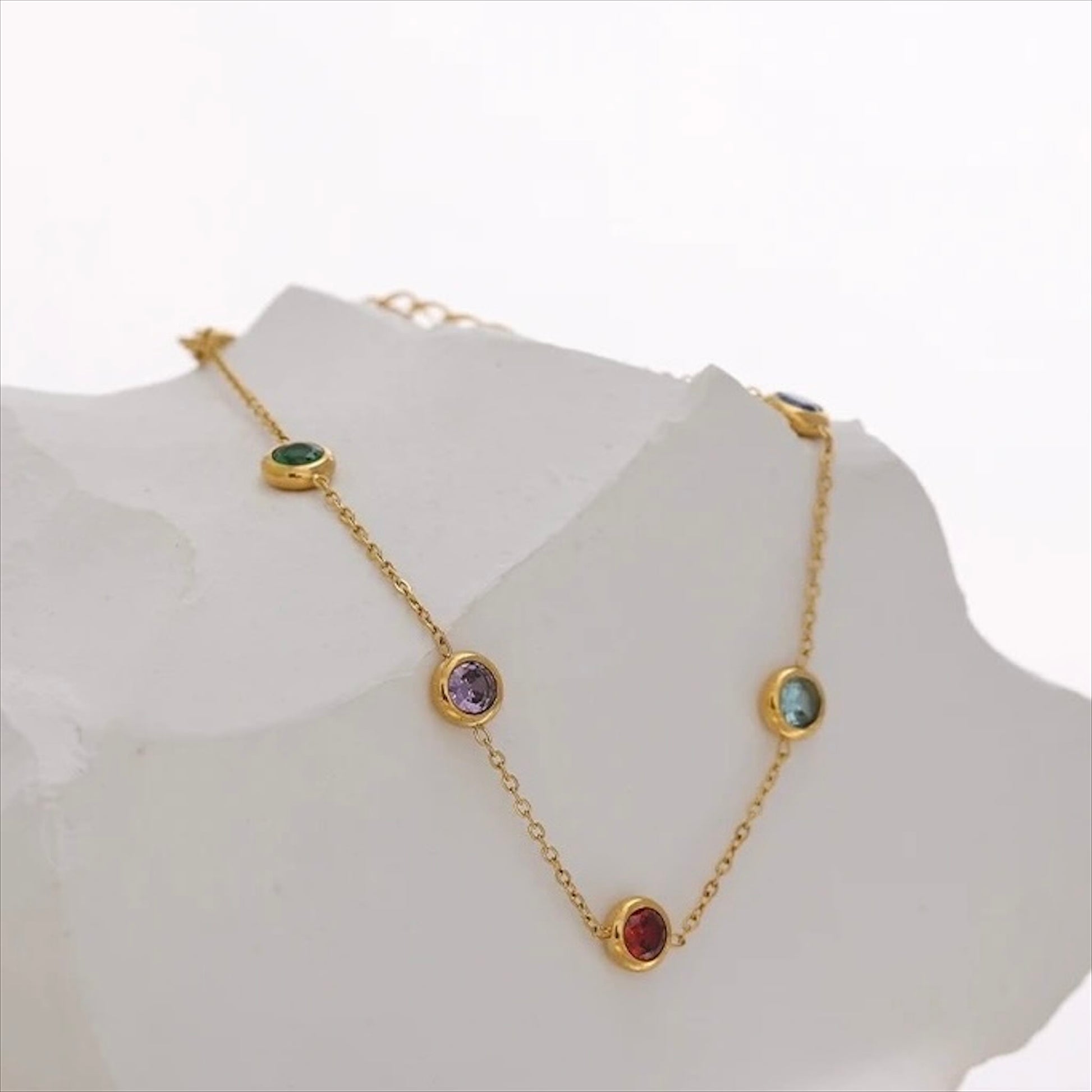 Bracelet fin doré en acier inoxydable avec pampilles pierres colorées, bijou délicat et tendance pour femme.