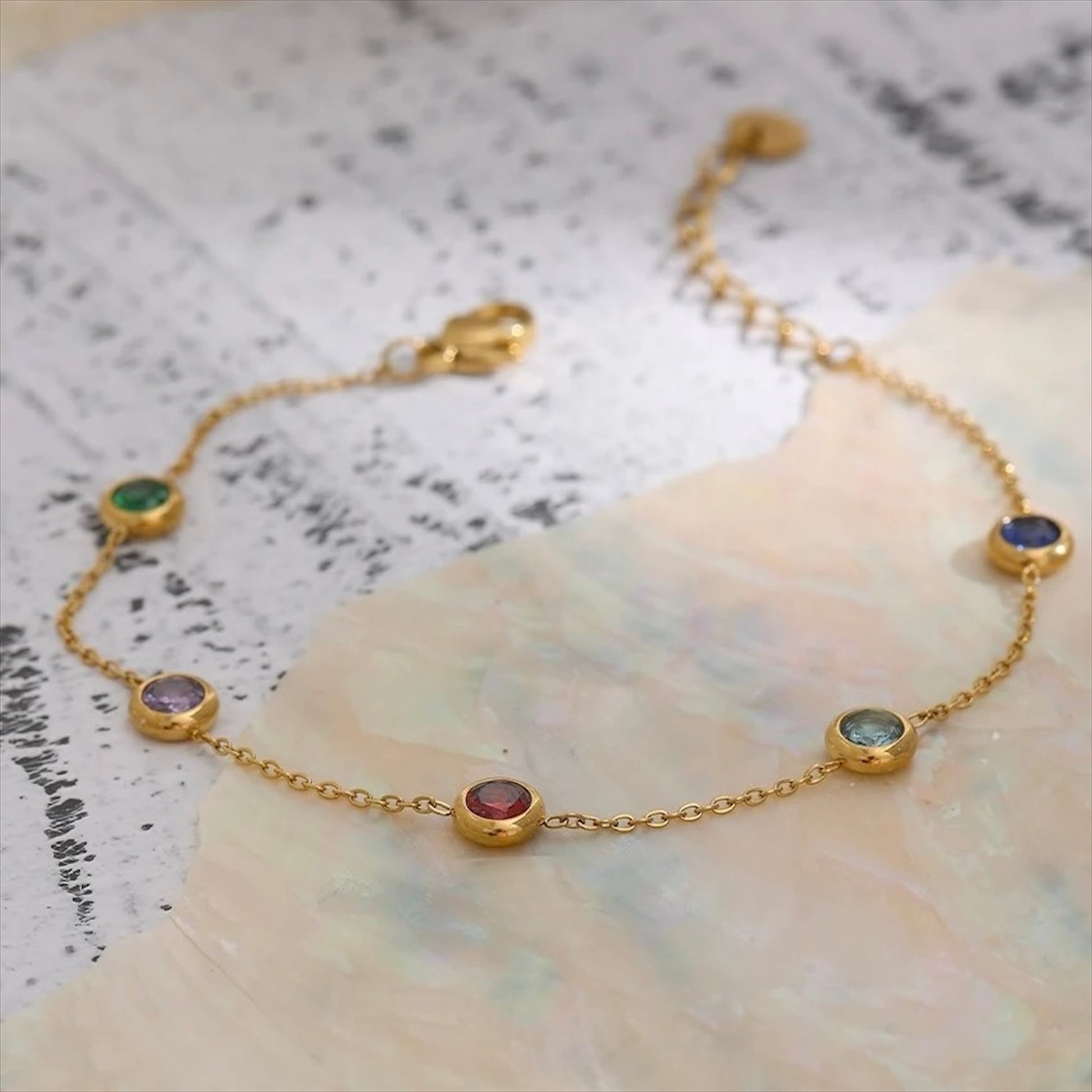 Bracelet fin doré en acier inoxydable avec pampilles pierres colorées, bijou délicat et tendance pour femme.