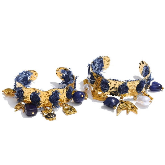 Bracelet jonc doré en acier inoxydable orné de denim bleu, perles et pampilles marines dorées, bijou tendance et original pour femme.
