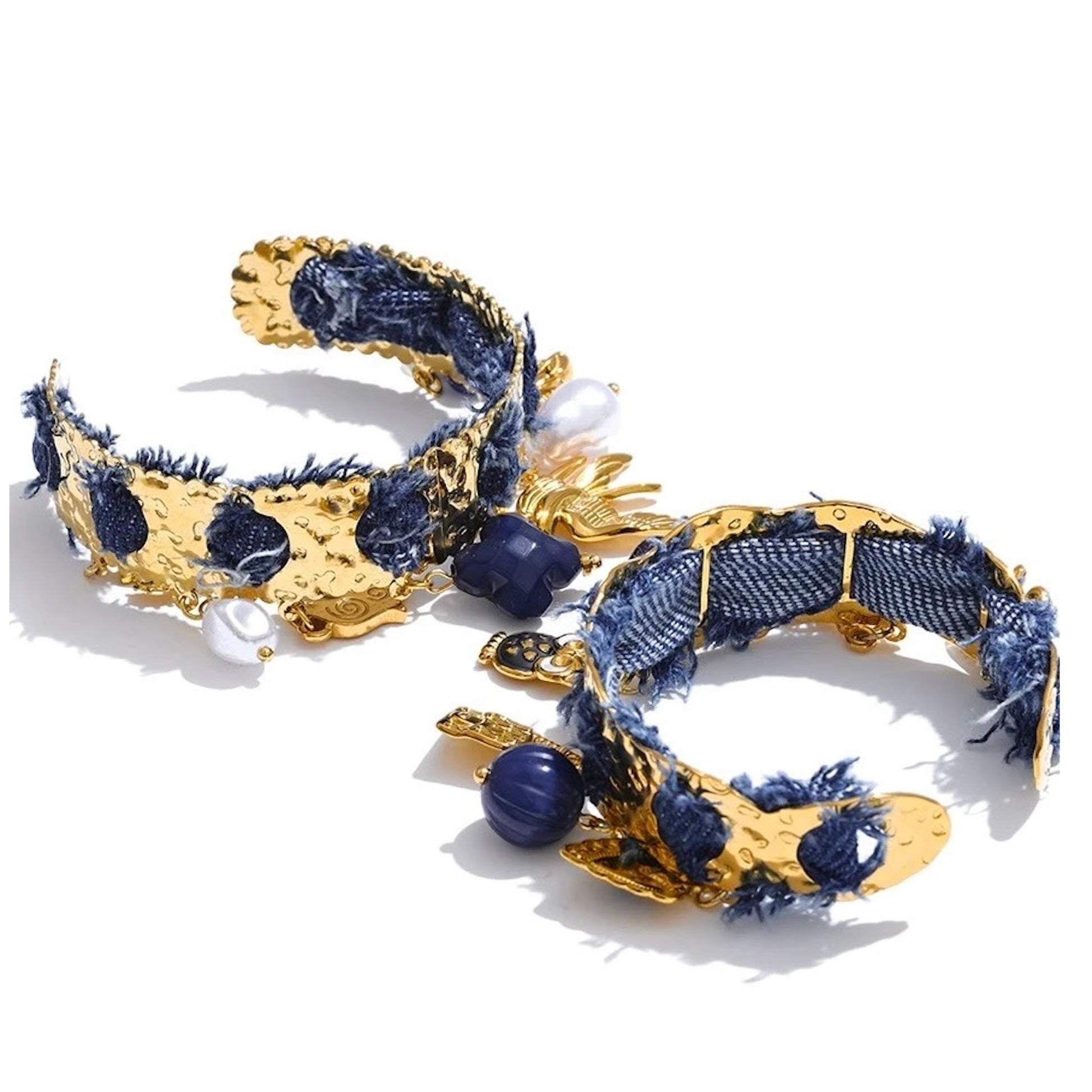 Bracelet jonc doré en acier inoxydable orné de denim bleu, perles et pampilles marines dorées, bijou tendance et original pour femme.