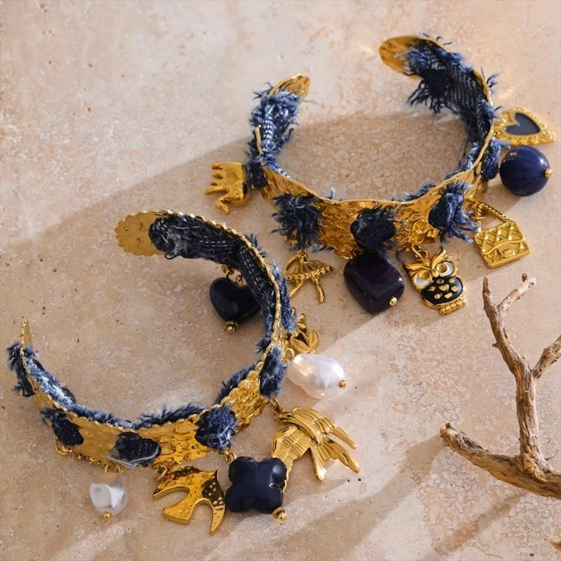 Bracelet jonc doré en acier inoxydable orné de denim bleu, perles et pampilles marines dorées, bijou tendance et original pour femme.