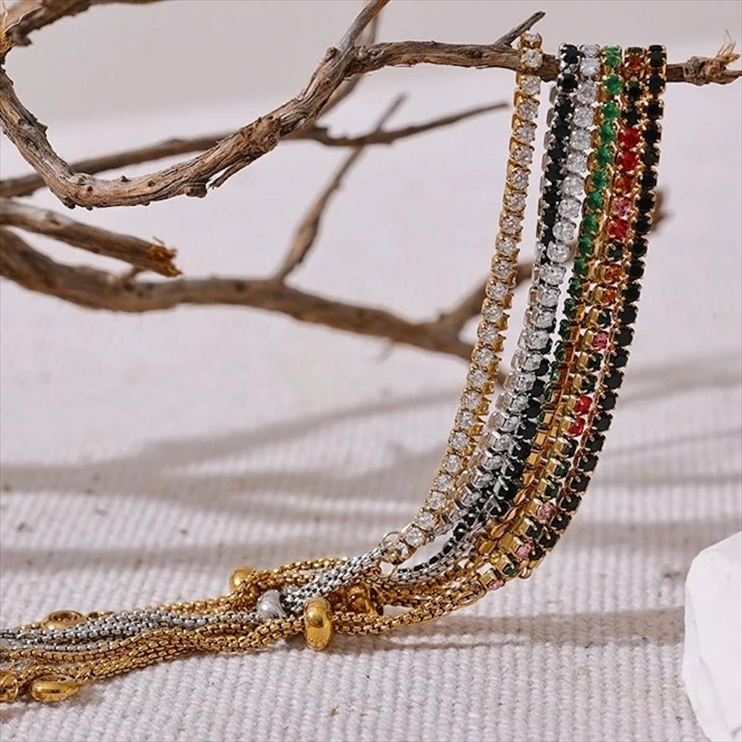 Bracelet tennis ajustable doré en acier inoxydable, serti de pierres colorées et zirconiums, bijou raffiné pour femme.