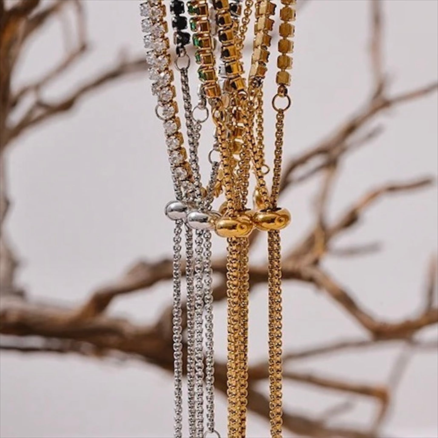 Bracelet tennis ajustable doré en acier inoxydable, serti de pierres colorées et zirconiums, bijou raffiné pour femme.
