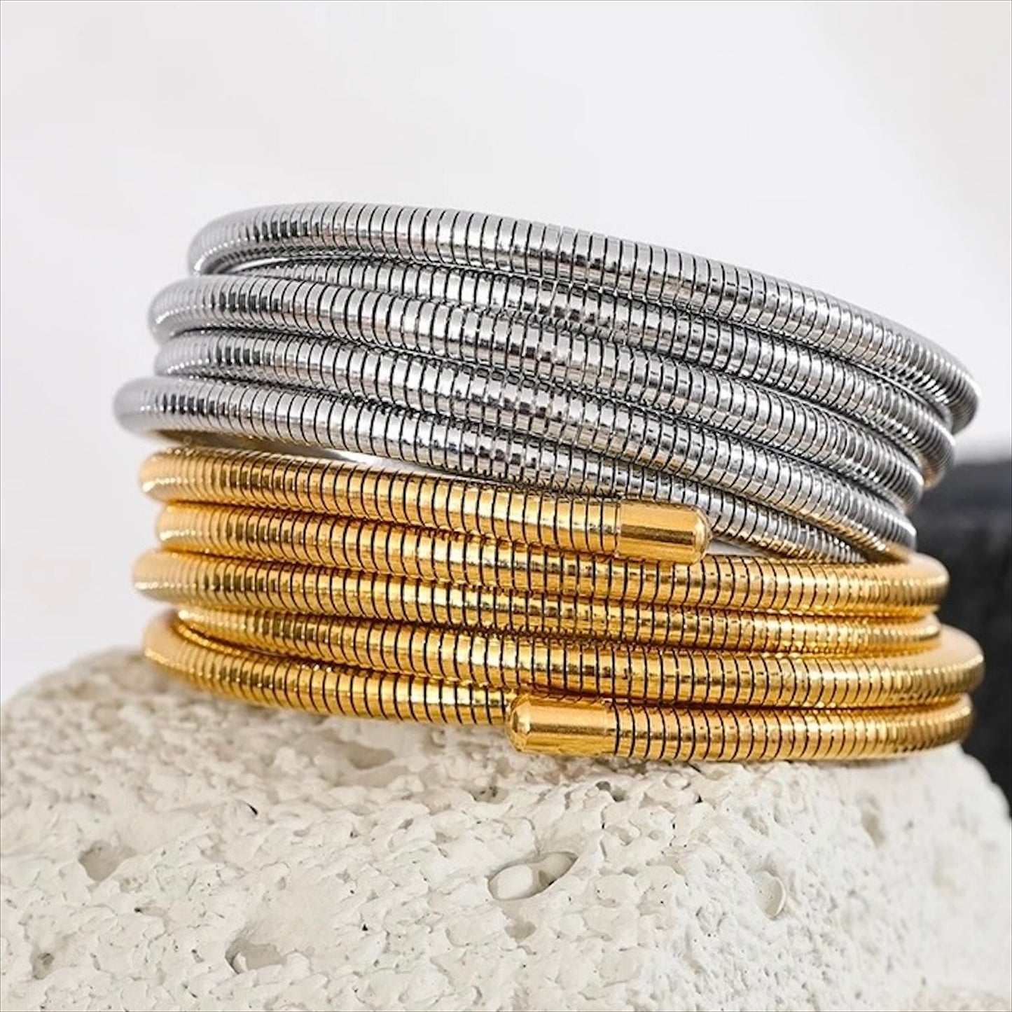 Bracelets spirale rigides en acier inoxydable, finitions dorée et argentée, bijoux robustes et modernes pour femme.