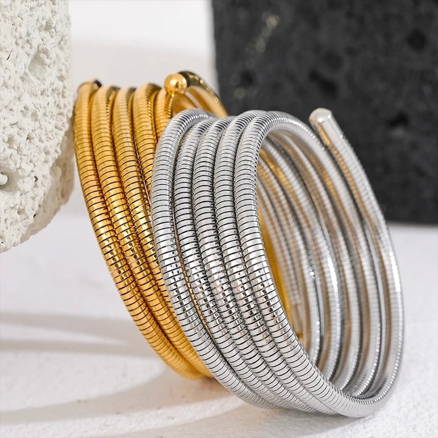 Bracelets spirale rigides en acier inoxydable, finitions dorée et argentée, bijoux robustes et modernes pour femme.