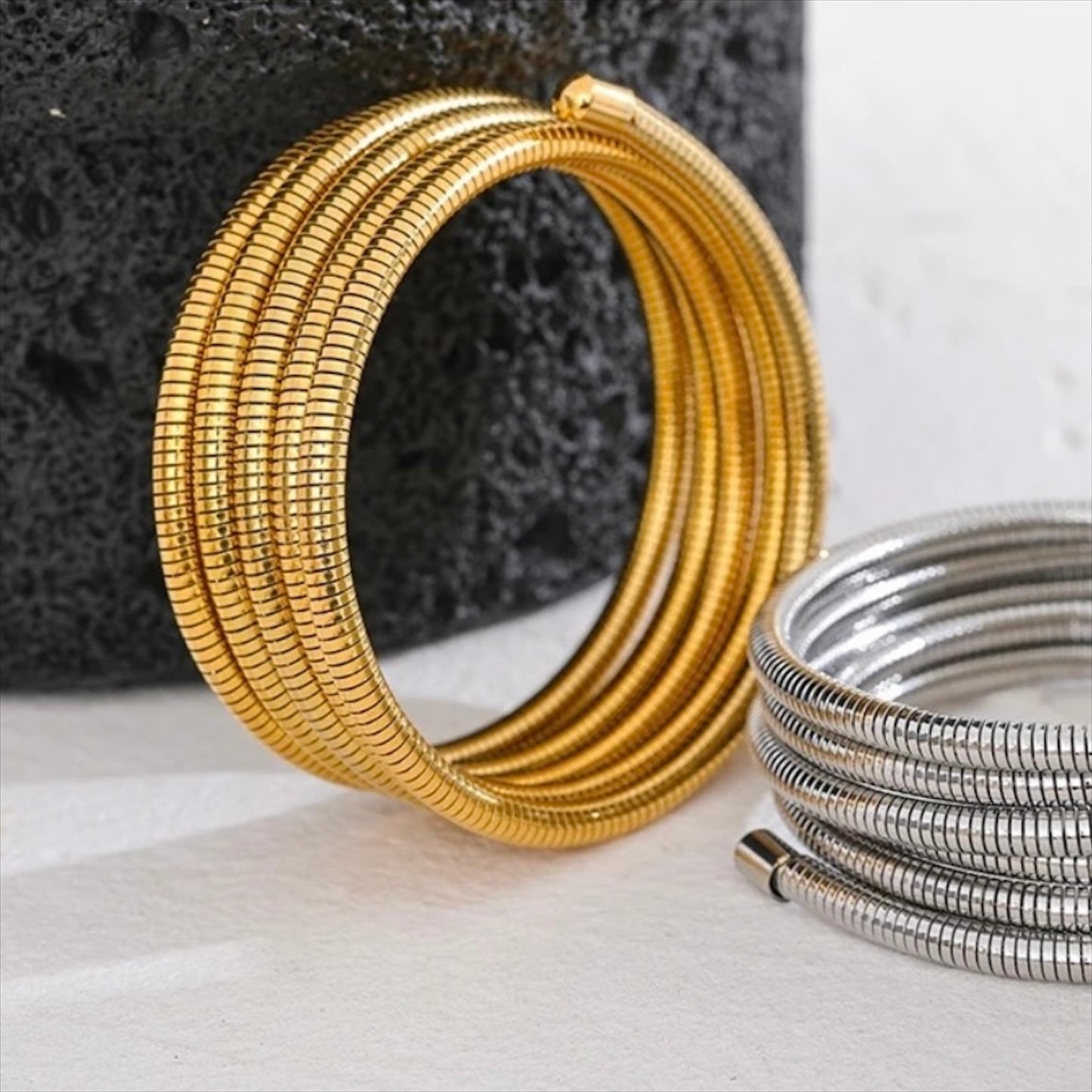 Bracelets spirale rigides en acier inoxydable, finitions dorée et argentée, bijoux robustes et modernes pour femme.